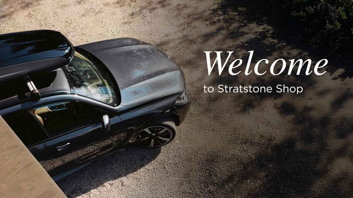 Welcome to Stratstone Shop homepage banner. Overhead shot of a car with a roofbox pulling off driveway.